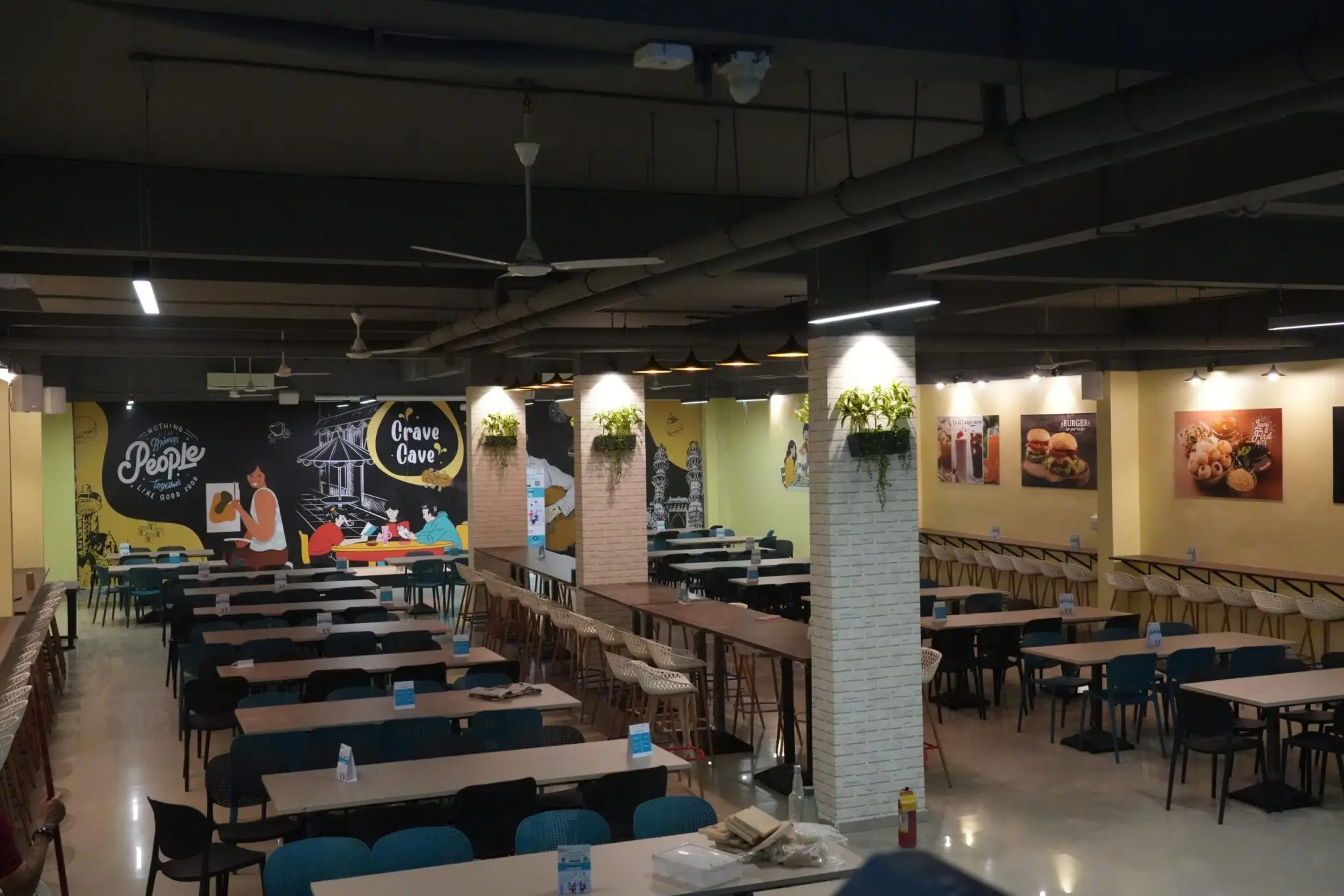 Modern and spacious cafeteria for students at a top MBA college in Delhi, featuring comfortable seating, wall art, and a vibrant dining environment.